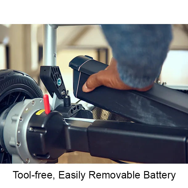 A close-up of a hand removing the battery from the Journey Zoomer Lightweight Folding Power Chair, with the caption “Tool-Free, Easily Removable Battery” below.
