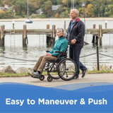 An older woman smiles while sitting in a Journey So Lite® C2 Ultra Lightweight Wheelchair, pushed by an older man along a waterfront path. Text at the bottom reads, Easy to Maneuver & Push.