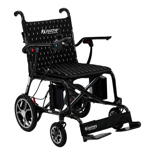 The Journey Air Elite Lightweight Folding Power Chair is black, lightweight, foldable, with a joystick armrest control, padded seat bearing the Journey logo, large rear wheels, and convenient footrests.