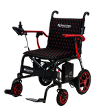 The Journey Air Elite Lightweight Folding Power Chair is a black and red compact wheelchair with joystick controls, cushioned seat and backrest, large rear wheels, small front wheels, footrests, and visible Journey branding.