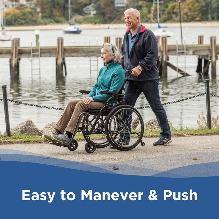 An older man pushes an older woman in a Journey So Lite® C2 Ultra Lightweight Wheelchair along the waterfront. Both are smiling, enjoying the smooth ride. Boats and docks appear in the background. Text reads: Easy to Maneuver & Push.
