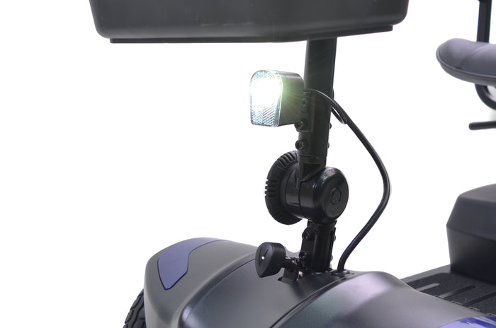 Close-up of the Journey Adventure Scooter’s illuminated front headlight, showing the handlebar, wheel fender, and seat against a white background—highlighting its convenient design for seniors.