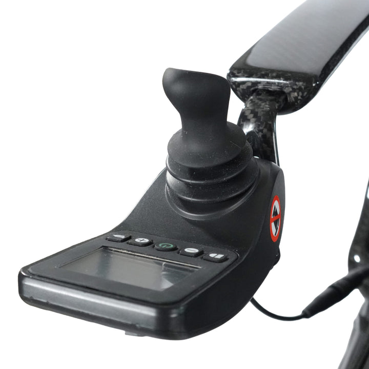 Close-up of the Journey Air Elite Max's black electronic joystick controller with buttons and display, likely installed on a mobility scooter or wheelchair featuring lightweight carbon fiber components.