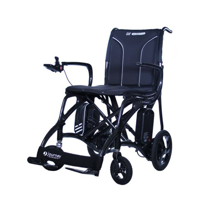 The Journey Air Elite Max is a black, lightweight carbon fiber electric wheelchair featuring joystick armrest control, footrest, sturdy frame, “Journey” on the footplate and “air elite” on the backrest, with a high weight capacity for reliable mobility.