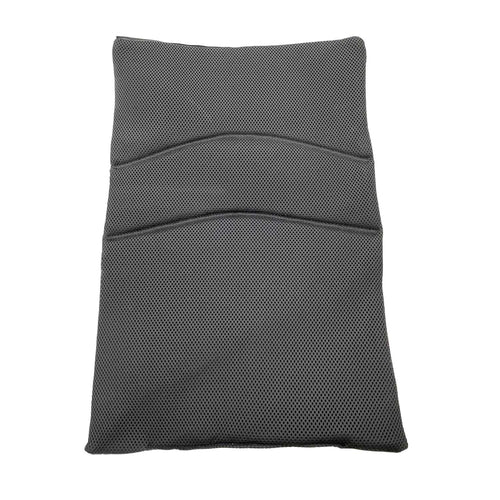 The Journey Air - Replacement Backrest, a black rectangular mesh cushion with curved stitching, lies flat on shiny beige tiles, designed specifically as a backrest replacement for the Journey wheelchair.