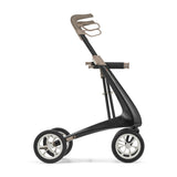 Side view of the byACRE Carbon Ultralight Rollator, a modern black carbon fiber mobility aid with large wheels and a beige ergonomic handlebar for easy movement.