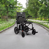 Journey Air 2026 portable folding electric power chair shown outdoors on a paved park path with green trees and white flowers, highlighting its travel-friendly design and 300lb weight capacity.