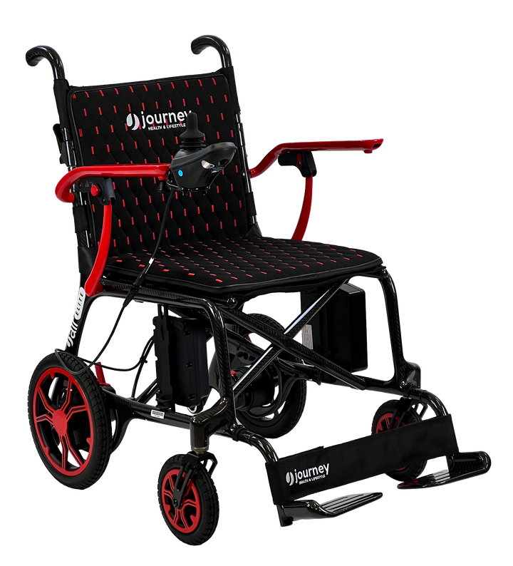 The CPO - Journey Air Elite Red (2025 Model) is a lightweight carbon fiber electric wheelchair in black and red, featuring journey branding, joystick control on the armrest, and foldable footrests. Shown on a plain white background.