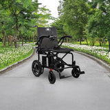 The Journey Air 2026 Portable Folding Electric Power Chair, with a 300 lb weight capacity, is placed on a paved path in a park bordered by green trees and white flowers.