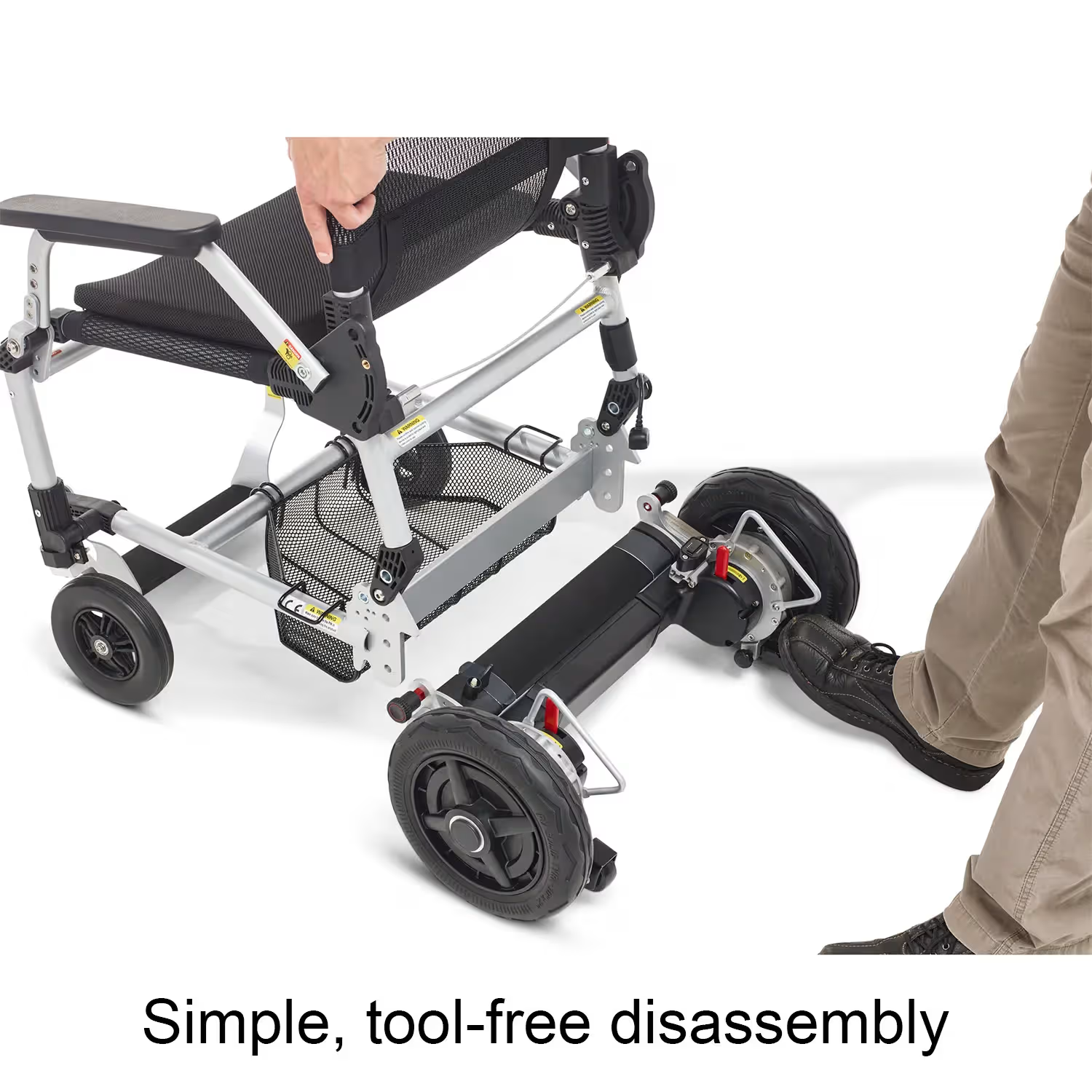 Person demonstrating tool-free disassembly of the Journey Zoomer lightweight folding power chair by separating the seat from the wheel base, highlighting simple and easy breakdown for transport and storage.