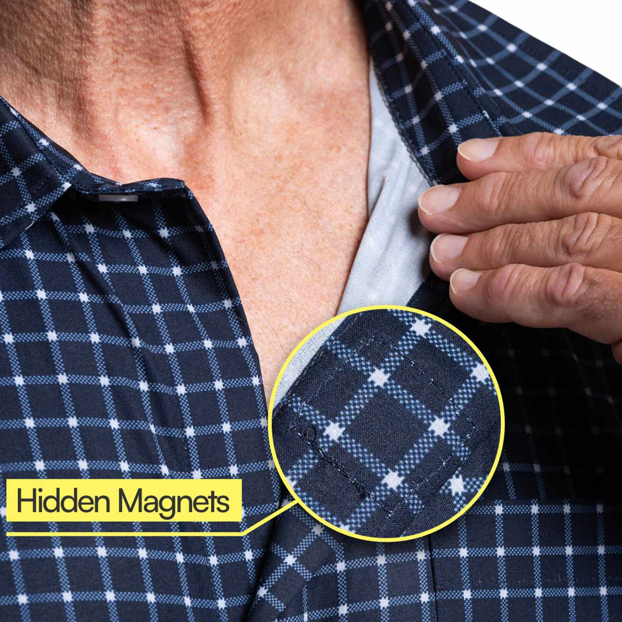 A person opens a Relaxed-Fit Magnetic Button-Down Shirt for Men with one hand, showing a close-up of the blue plaid fabric. A yellow circle highlights hidden magnets in the shirt, labeled Hidden Magnets to show its adaptive design.