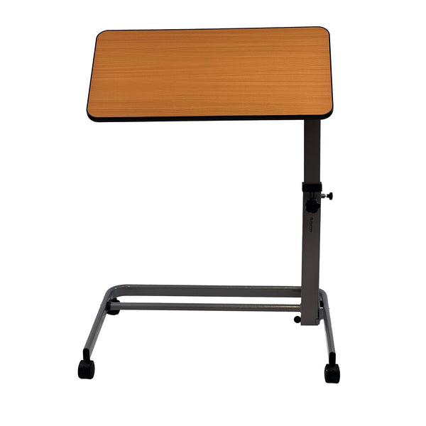The Journey Foldable Overbed Table is a compact, adjustable-height table with a light wood surface and gray metal frame on four wheels, ideal for use beside a bed or chair.