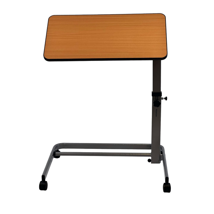 The Journey Foldable Overbed Table is a compact, adjustable-height table with a light wood surface and gray metal frame on four wheels, ideal for use beside a bed or chair.
