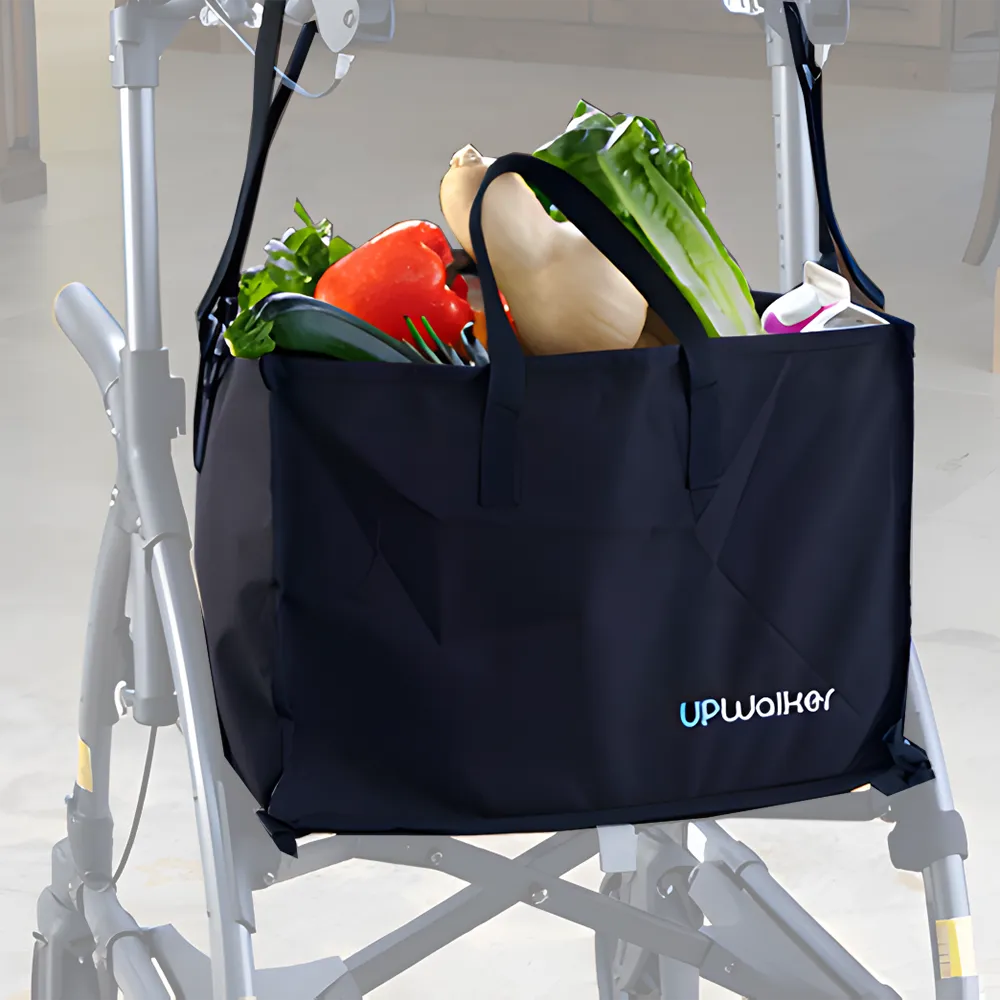 A Journey UPWalker Personal Shopping Bag in black, filled with lettuce, bell pepper, squash, and eggplant, hangs on a silver walker in a store—showcasing this convenient accessory.