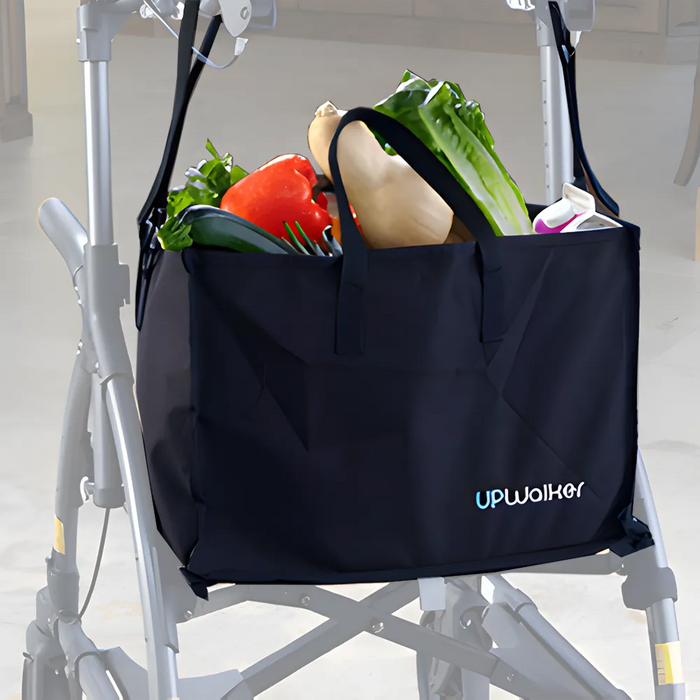 A Journey UPWalker Personal Shopping Bag in black, filled with lettuce, bell pepper, squash, and eggplant, hangs on a silver walker in a store—showcasing this convenient accessory.