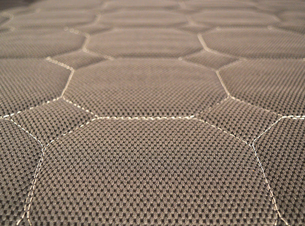 Close-up of the UPbed® Standard 4-in-1 Motorized Lift Bed’s grayish-brown fabric, showing a hexagonal stitched pattern with raised, padded sections and visible seams—evoking plush comfort similar to memory foam.