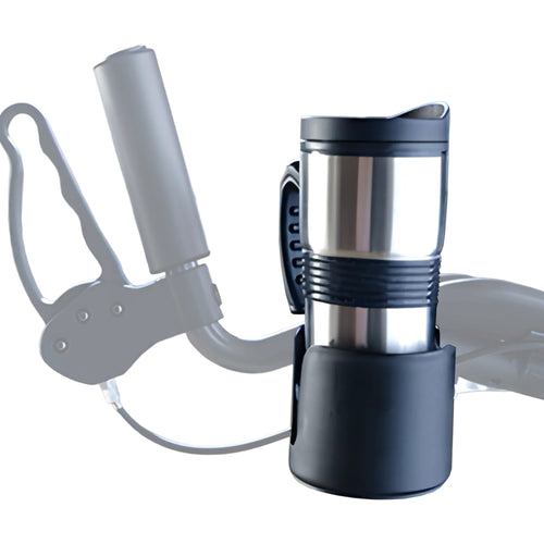 A stainless steel travel mug with a handle sits securely in the UPWalker® Beverage Holder, a black accessory attached to a mobility device handlebar, with a blurred background highlighting this practical UPWalker add-on.