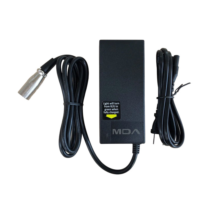 The Journey Zoomer Power Chair Charger – Replacement w/Power Wire is a black charger with a rectangular body, indicator label, built-in power wire, and silver cylindrical connector, ideal for Zoomer Power Chair users. Another cord is coiled beside it.