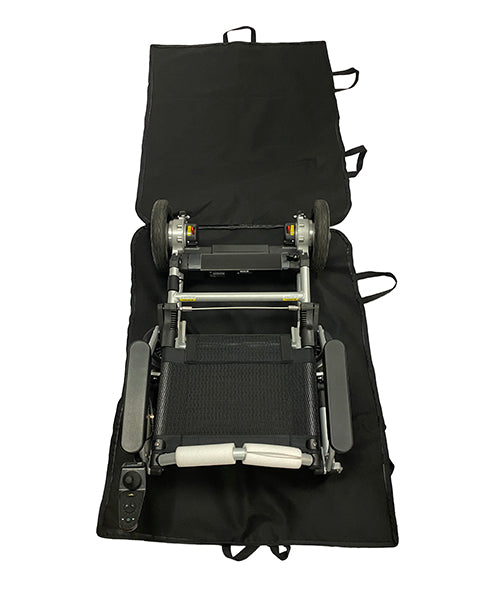 A folded electric wheelchair sits on an open Journey Zinger & Zoomer Power Chair Travel Bag, showing its wheels, seat, and control panel. The black bag has multiple handles along the edges for easy carrying.