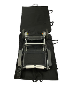 A folded electric wheelchair sits on an open Journey Zinger & Zoomer Power Chair Travel Bag, showing its wheels, seat, and control panel. The black bag has multiple handles along the edges for easy carrying.